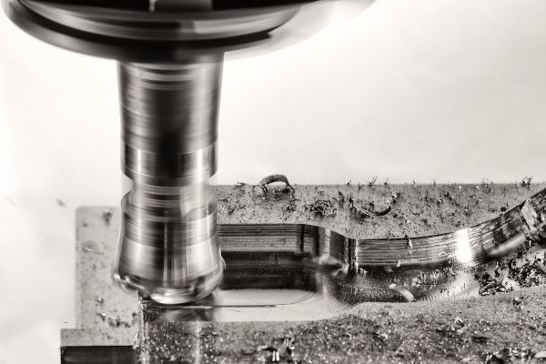 a milling machine cutting out a piece from metal